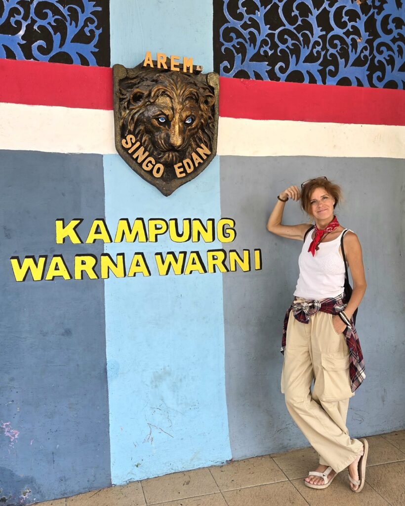 Napis Kampung Warna Warni i herb klubu Arema Singo Edan na ścianie