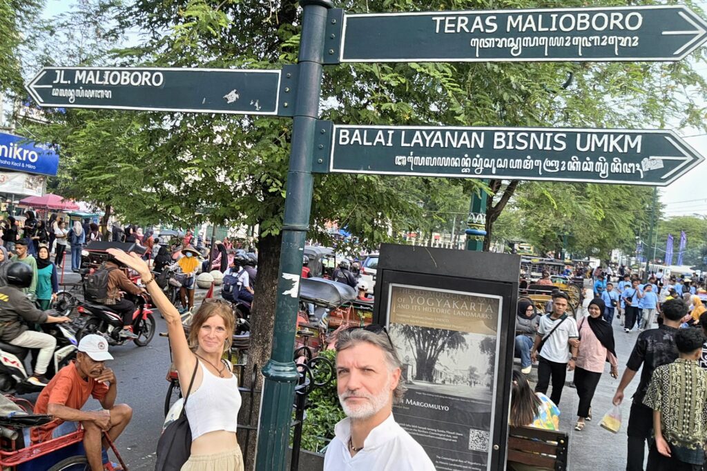Tabliczki z nazwami ulic przy wejściu na Malioboro, tłum turystów