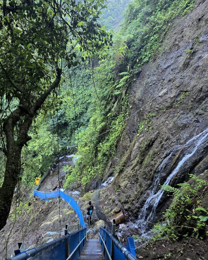 Metalowe schody i konstrukcje przymocowane do skalnej ściany na trasie do Tumpak Sewu