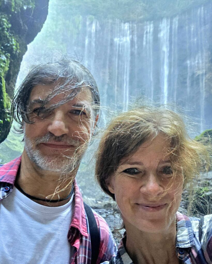 Baś i Piotr u stóp wodospadu Tumpak Sewu, mokrzy od wodnego pyłu